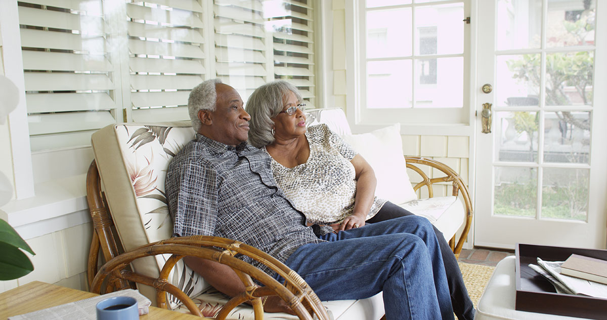 Black older couple on porch bench looking outward